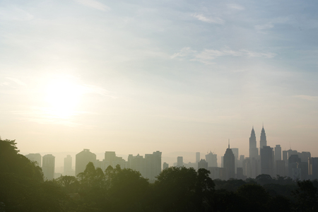 Beautiful kuala lumpur cityscape skyline and surrounding nature with hazy or foggy morning sunshine silhouette buildings and trees nature and development concept