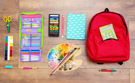 School set with backpack palette and supplies on wooden background