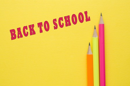 Bright colored pencils on yellow background back to school Stock Photo