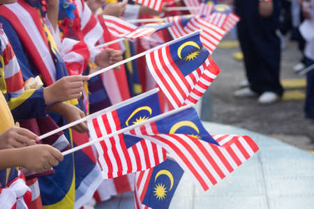 Hand waving malaysia flag also known as jalur gemilang in conjunction with the independence day celebration or merdeka day