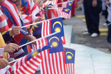 Hand waving malaysia flag also known as jalur gemilang in conjunction with the independence day celebration or merdeka day Stock Photo