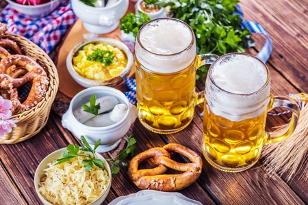 Oktoberfest beer pretzels and various bavarian specialties on wooden background