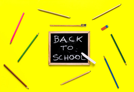 Back to school concept chalkboard with pencils on yellow background