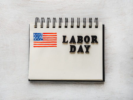 Labor day notepad american flag pattern and wooden letters of the alphabet on a white table close up bright photo and space for your inscriptions congratulations to relatives friends colleagues Stock Photo