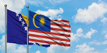 Bosnia herzegovina and malaysia flag waving in the wind against white cloudy blue sky together diplomacy concept international relations Stock Photo