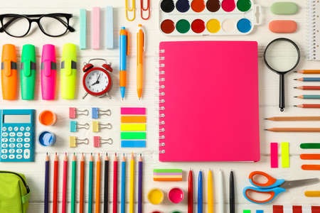 Flat lay composition with school supplies on white wooden background