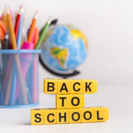 Back to school text on yellow cubes school supplies on white background sale of stationery