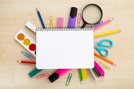 School supplies with blank sheet of paper on brown wooden table Stock Photo