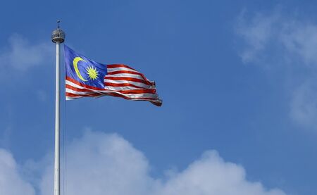 Malaysia flag also known as jalur gemilang waving with the blue sky background in conjunction of independence day or merdeka day celebration on 31 august and hari malaysia on 16 september