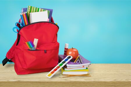 Blue school backpack on wooden table