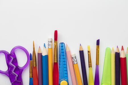 Row of school art and craft supplies on a white background