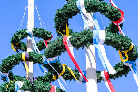 Typical bavarian maypole in front of blue sky