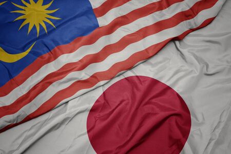 Waving colorful flag of japan and national flag of malaysia macro Stock Photo