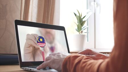 Doctor on the screen of computer and the stethoscope with flag of malaysia malaysian telemedicine