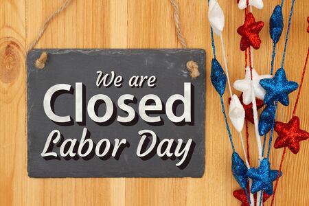 We are closed labor day chalkboard sign with red white and blue stars on wood