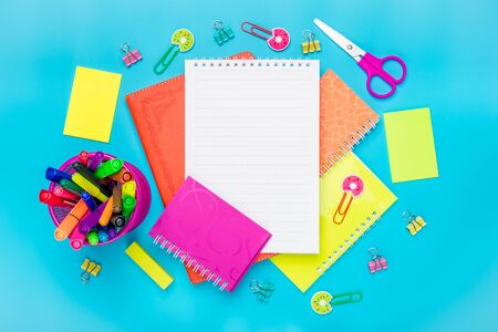 Stationary back to school summer time creativity and education concept supplies scissors pencils paper clips note and notepad magnifier on blue background flatlay mock up top view banner