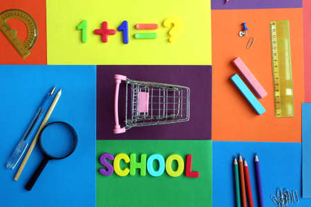 An empty shopping cart stands surrounded by stationery