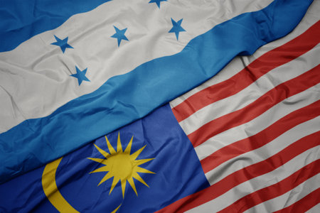 Waving colorful flag of malaysia and national flag of honduras macro Stock Photo