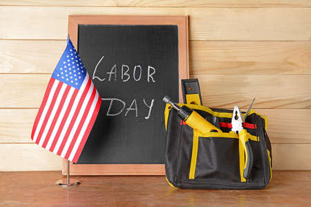 Set of tools usa flag and chalkboard with text labor day on wooden background