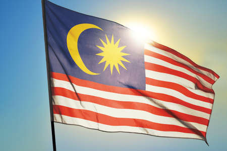 Malaysia flag waving on the wind in front of sun