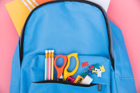 Top view flat lay of blue school bag backpack and accessories tools for children education on pink background back to school concept and have copy space for use