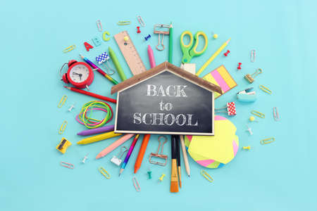 Back to school concept top view image of blackboard and student stationery over pastel blue background