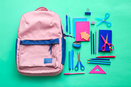 School backpack and stationery on color background Stock Photo