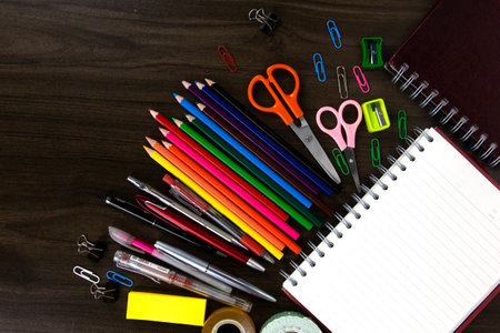 Books with color pencils and education elements back to school concepts on dark wood background Stock Photo