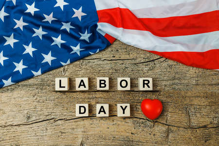 Us american flag with wooden cubes with word labor day on old wooden background labor day celebration