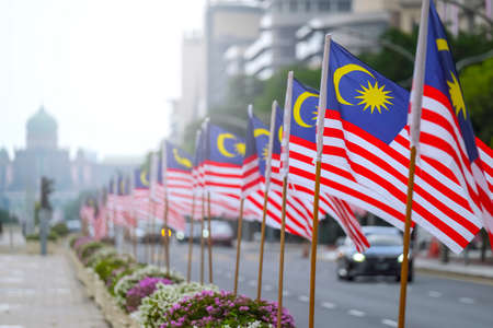 The malaysia flag is also known as jalur gemilang waving with a city in the background independence day or merdeka day celebration on 31 august and hari malaysia on 16 september copy space concept