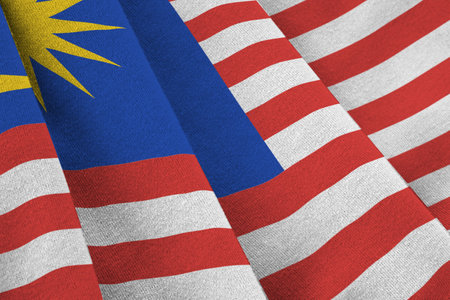 Malaysia flag with big folds waving close up under the studio light indoors the official symbols and colors in fabric banner