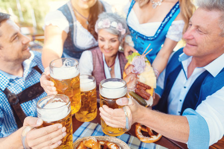 Group of friends toasting in beer garden Stock Photo