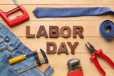 Composition with text labor day different tools jeans and tie on wooden background