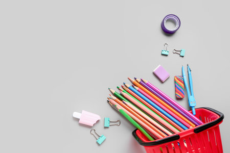 Shopping basket with different school stationery on gray background Stock Photo