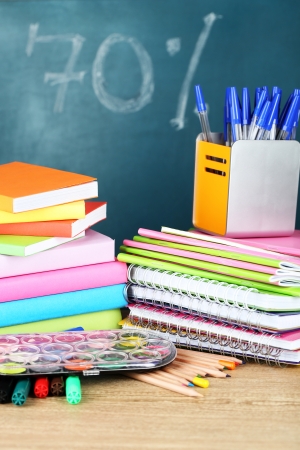 Office supplies on table on school board background