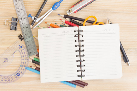 Notebook paper and school or office tools on wood table for background vintage effect Stock Photo