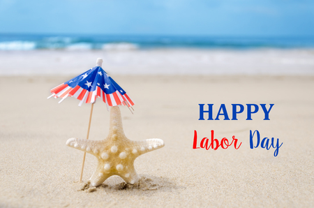 Labor day usa background with starfishes and decorations on the sandy beach Stock Photo