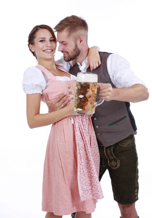 Bavarian couple in traditional costume with beer and brezel