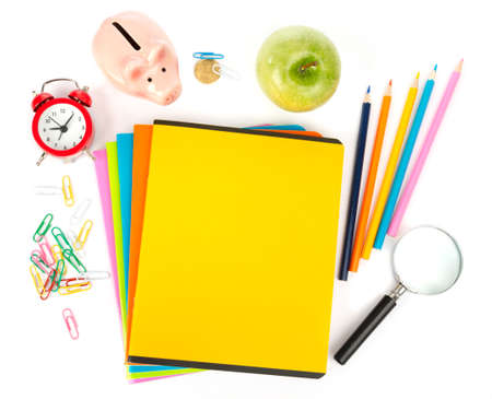 Pencil cup with crayons alarm clock and apple on copybooks on isolated white background Stock Photo