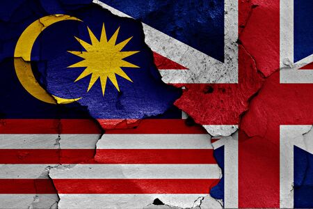 Flags of malaysia and uk painted on cracked wall