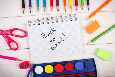 Office accessories on white boards inscription back to school in notepad Stock Photo