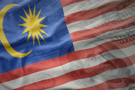 Colorful waving national flag of malaysia on a american dollar money background finance concept Stock Photo