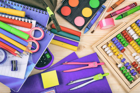 Variety of school supplies on wooden background