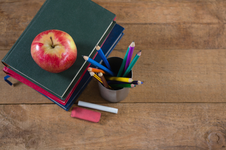 Close up of school supplies and books stack with apple on top Stock Photo