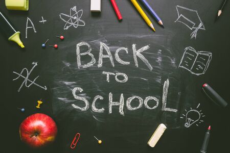 Back to school school supplies on the chalkboard background education concept