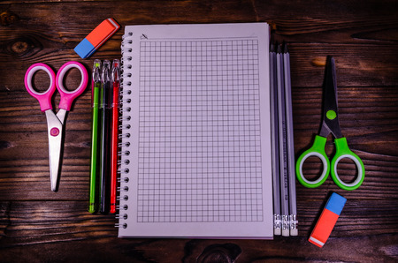 Set of different school stationeries notepad scissors pensils on rustic wooden desk back to school top view