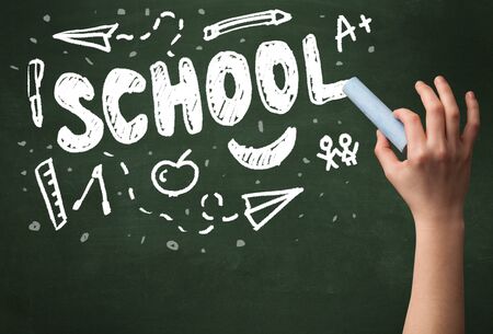 A teacher writing school drawing children things on clean green chalkboard by hand