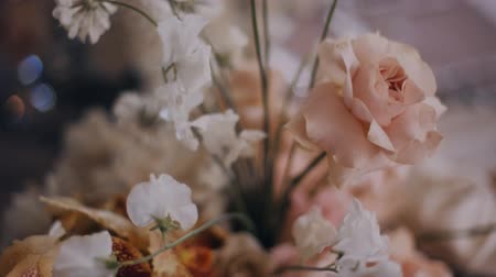 Dolly in shot of beautiful peach colour floristic composition on wedding party banquet table. Middle shot.